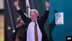 Pendiri WikiLeaks Julian Assange mengangkat kedua tangan, setelah mendarat sebagai orang bebas di pangkalan udara RAAF Fairbairn di Canberra, Australia, Rabu 26 Juni 2024.