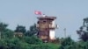 ແຟ້ມຮູບ-ທະຫານເກົາຫຼີເໜືອຄົນນຶ່ງ ຢືນຢູ່ປ້ອມຍາມກອງທັບ ຂອງເກົາຫຼີເໜືອ ໃນຂະນະທີ່ທຸງຂອງເກົາຫຼີເໜືອ ປິວໄປມາຕາມລົມ, ຮູບພາບທີ່ຖ່າຍຈາກເມືອງ ເປຈູ, ເກົາຫຼີໃຕ້, ວັນທີ 24 ກໍລະກົດ 2024.