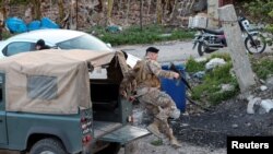 A Lebanese army soldier jumps off a military vehicle in Al Qulaylah in southern Lebanon, April 7, 2023. The army said on Saturday it had arrested a prominent al-Qaida leader in Deir Ammar town, northeast of the city of Tripoli.