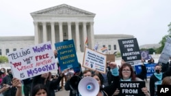Para demonstran pro hak-hak aborsi melakukan aksi protes di luar Mahkamah Agung AS di Washington DC, untuk menentang rancangan keputusan MA yang dapat membatalkan aturan yang melegalkan aborsi secara nasional, Selasa (3/5). (Foto: AP)