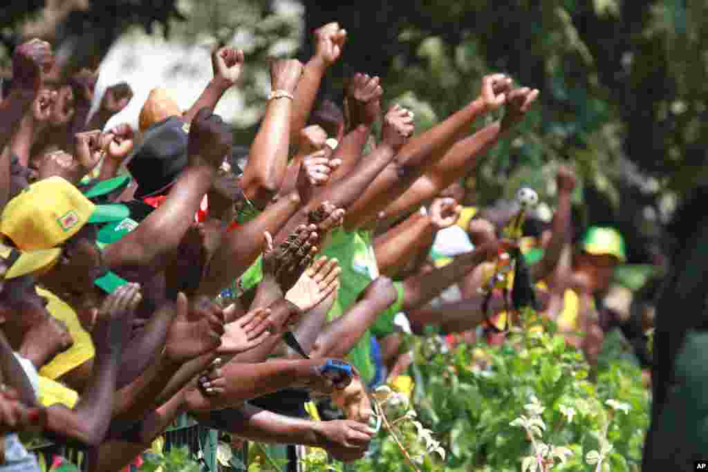 Supporters of Zimbabwean President Robert Mugabe cheer upon his arrival for the opening of the first session of the eighth Parliament of Zimbabwe in Harare, Sept. 17, 2013. 