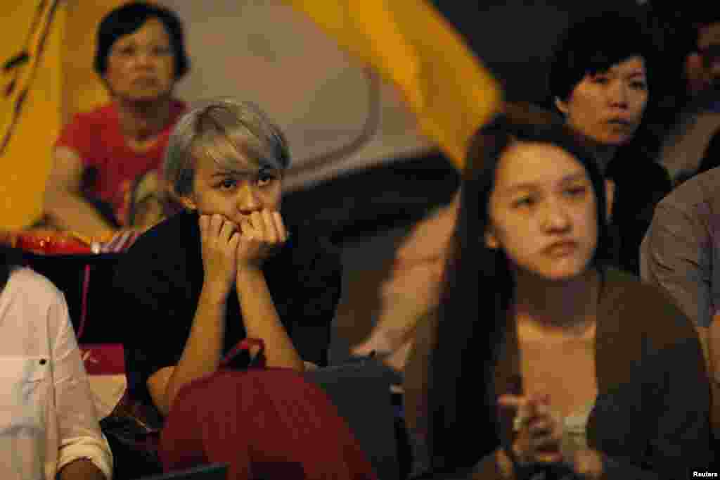 Pro-democracy protestors watch formal talks between student protest leaders and city officials on a video screen near the government headquarters in Hong Kong, Oct. 21, 2014. 