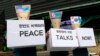 韩国抗议人士戴着用美国、朝鲜和韩国国旗信封做成的面具要求立即举行和平会谈