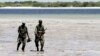Somalia's Transitional Federal Government (TFG) soldiers patrol the Indian Ocean coastline in Burgabo, south of Kismayu in Somalia, December 14, 2011