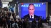 Participants at the St. Petersburg International Economic Forum gather near a screen showing Russian President Vladimir Putin