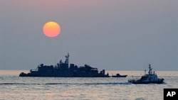FILE - A South Korean goverment ship (R) sails by Navy MSB (Movement Sea Base) off the South Korea-controlled island of Yeonpyeong near the disputed waters of the Yellow Sea.