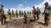 FILE - Somali soldiers stand at a Somali military base, near the site of an attack by al-Shabab, in Lower Juba, June 13, 2018. The base was the target of another al-Shabab assault Monday.