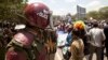 A riot policeman stands guard as opposition party supporters shout slogans during a march in Nairobi, Kenya, Oct. 9, 2017. 