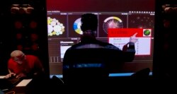 FILE - An analyst points to a screen at Government Communications Headquarters (GCHQ), Britain's electronic intelligence service, in London, March, 14, 2014.