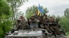 Ukrainian soldiers sit on top of an APC after a Ukrainian checkpoint was attacked by pro-Russians near the village of Blahodatne, eastern Ukraine, May 22, 2014.