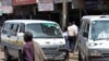 A man walks past two Kenyan minibuses in Nairobi.