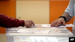 FILE - An early voter casts his vote in the polling station on the outskirts of Sofia, Bulgaria, June 9, 2024.