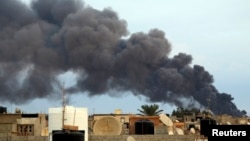 Smoke billows from a factory after an airstrike by forces loyal to former general Khalifa Haftar, in Benghazi, Libya, Oct. 22, 2014.