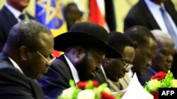 President of South Sudan, Salva Kiir signs a final power-sharing deal between South Sudanese arch-foes, Aug. 5, 2018, in Khartoum.