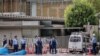 Police investigate a vehicle that crashed into a barricade outside the prime minister's Tokyo residence on Oct. 19, 2024, after a man threw Molotov cocktail-like objects outside the ruling party's headquarters building, hit a riot police vehicle and drove into the barricade.