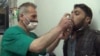 FILE - This video image from an anti-Bashar al-Assad activist group shows a Syrian man being treated with an inhaler in Kfar Zeita, north of Damascus, after what witnesses said was a chlorine gas attack, April 18, 2014.