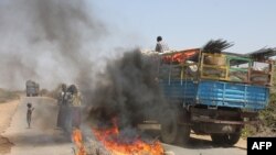FILE - A truck passes a partial roadblock set up by residents as a protest against al-Shabab insurgents, outside Mogadishu, March 6, 2014.