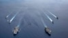 FILE - In this photo provided by U.S. Navy, the USS Ronald Reagan (CVN 76) and USS Nimitz (CVN 68) Carrier Strike Groups steam in formation, in the South China Sea, July 6, 2020. 