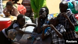 South Sudanese fleeing an attack on the South Sudanese town of Rank, wait with their belongings after arriving at a border gate in Joda, along the Sudanese border, April 19, 2014.