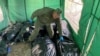 Ritual worker picks up bodies of killed Russian soldiers to load them to refrigerated rail car, in Kharkiv