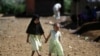 FILE - Young girls hold hands as they walk down a road in Marawi City, southern Philippines, June 15, 2018. A coronavirus lockdown in the region has brought a welcome reprieve in fighting between government forces and Muslim rebels seeking independence.