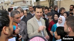 Syrian President Bashar al-Assad chats with people during his visit to Ein al-Tinah village, northeast of Damascus, April 20, 2014.