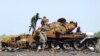 Representatives of the separatist self-proclaimed Donetsk People's Republic inspect a burnt tank during a joint operation to search for the remains of killed soldiers at the city's airport in Donetsk, Ukraine, May 22, 2015. Officials and the military repr