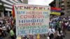 Simpatizantes de la oposición protestan contra el presidente Nicolás Maduro portando un cartel que dice "Venezuela está herida en el corazón con hambre, miseria, corrupción y dictadura", en Caracas, Venezuela, 10 de mayo de 2017.