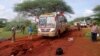 Kenyan security forces and others gather around the scene on an attack on a bus about 50 kilometers (31 miles) outside the town of Mandera, near the Somali border in northeastern Kenya, Nov. 22, 2014.