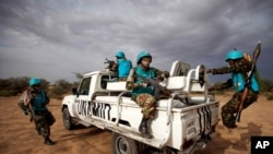 FILE - In this photo released by the United Nations African Union Mission in Darfur (UNAMID), Tanzanian UNAMID troops patrol Khor Abeche, South Darfur, Sudan.
