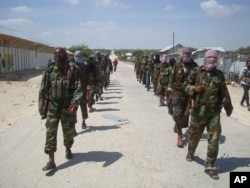FILE - Members of Somalia's al-Shabab militant group patrol on foot on the outskirts of Mogadishu, Somalia, March 5, 2012.