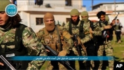 FILE - This photo posted on the Twitter page of Syria's al-Qaida-linked Nusra Front on April 1, 2016, shows fighters from al-Qaida's branch in Syria, the Nusra Front, marching toward the northern village of al-Ais in Aleppo province, Syria.