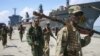 Somali National Army soldiers and pro-government Ras Kamboni brigadiers walk along seaport quay, Kismayo, Nov. 2, 2012.