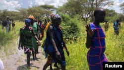 South Sudanese women walk to the site of a U.N. World Food Program (WFP) food aid air drop near the town of Katdalok, in Jonglei State of South Sudan, July 30, 2018.