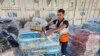 ​ພະ​ນັກ​ງານ​ອົງ​ການ​ສະ​ຫະ​ປະ​ຊາ​ຊາດ​ຄົນ​ນຶ່ງ ກະ​ກຽມ​ການ​ຊ່ວຍ​ເຫຼືອ ເພື່ອ​ແຈກຢ​າຍ​ໃນ​ຊາວ ປາ​ແລັ​ສ​ໄຕ​ນ ຢູ່​ສາງ​ຂອງ​ອົງ​ການ UNRWA , ໃນ​ເມືອງ ແດ ອາ​ລ-ບາ​ລາ, ເຂດ​ກາ​ຊາ, 23 ຕຸ​ລາ 2023.