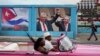 Un automóvil antiguo pasa junto a una imagen del expresidente de Cuba, Raúl Castro, y del presidente y primer secretario del Partido Comunista de Cuba, Miguel Díaz-Canel, junto a un cartel que dice: "Somos continuidad", en La Habana, Cuba, el 17 de abril de 2023.