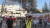 A Palestinian reacts as smokes rises at the scene of what witnesses said was Israeli shelling near a market in Shejaia in the east of Gaza City, July 30, 2014. 