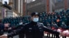 FILE - A policeman moves journalists back from an event held for the last group of medical workers who came from outside Wuhan to help the city during the coronavirus outbreak, in Wuhan, China, April 15, 2020. 
