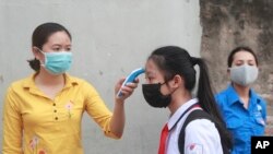 A student is scanned for temperature before entering Dinh Cong secondary school in Hanoi, Vietnam Monday, May 4, 2020.