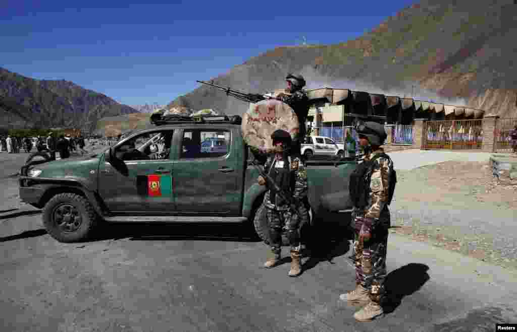 Afghan security personnel keep watch at the site of a suicide attack in Panjshir, Afghanistan, May 29, 2013. 