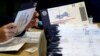 FILE - An election worker processes mail-in and absentee ballots in West Chester, Pennsylvania, Nov. 4, 2020. While there's already been a steady buildup of influence operations in the run-up to the November polls, the worst may be yet to come, officials and experts warn.