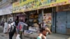 FILE - Kenyans walk past closed shops in the capital after an attack on a hotel complex, claimed by al-Shabab, in Nairobi, Kenya, Jan. 18, 2019.