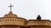 Seorang anggota keamanan berjaga di atas sebuah gereja selama misa pada Malam Natal di gereja Mar Shimoni di kota Bartella, timur Mosul, Irak, 24 Desember 2016. (Foto: Reuters)