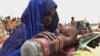 FILE - A mother quenches her malnourished child's thirst while waiting for food handouts at a health center in drought-stricken remote Somali region of Eastern Ethiopia.