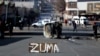 Voiture brûlée et rue bloquée à Johannesburg, en Afrique du Sud, le 11 juillet 2021, suite à de violentes manifestations après l'incarcération de l'ancien président Jacob Zuma.