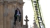 Un hombre con una bandera palestina reacciona junto a los socorristas mientras se encuentra en la Torre Elizabeth, comúnmente conocida como Big Ben, junto a las Casas del Parlamento, en Londres, Gran Bretaña, el 8 de marzo de 2025.