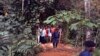 Des policiers encadrent un groupe d’homme près des tombes nouvellement creusées dans la jungle à Ndenga Mongo, province de Kasaï, RDC, 4 août 2007. 
