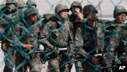 南韓士兵在非軍事區附近演習時走過一道鐵絲網